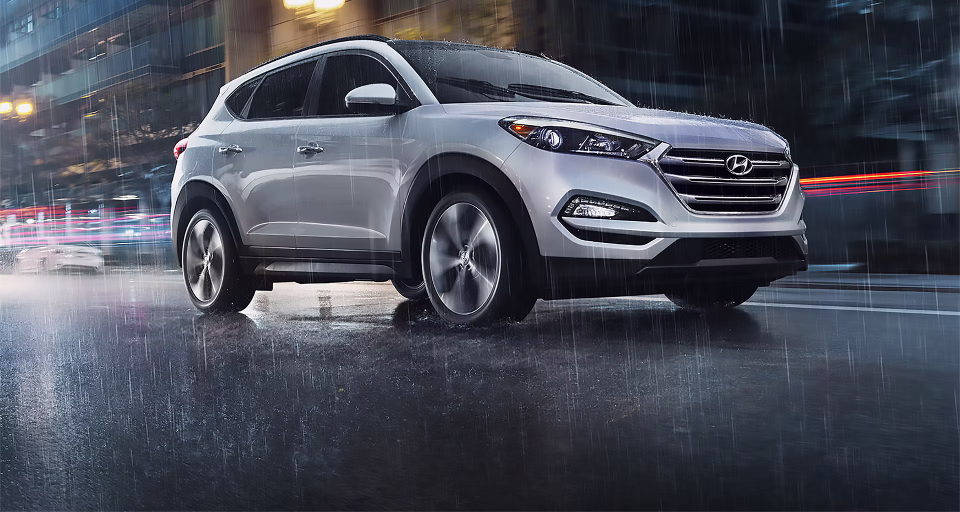 Hyundai on a wet city road at night